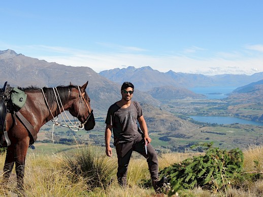 Volunteer Alex Brown-Hunt conquers a wilding pine while his trusty steed Harley looks on